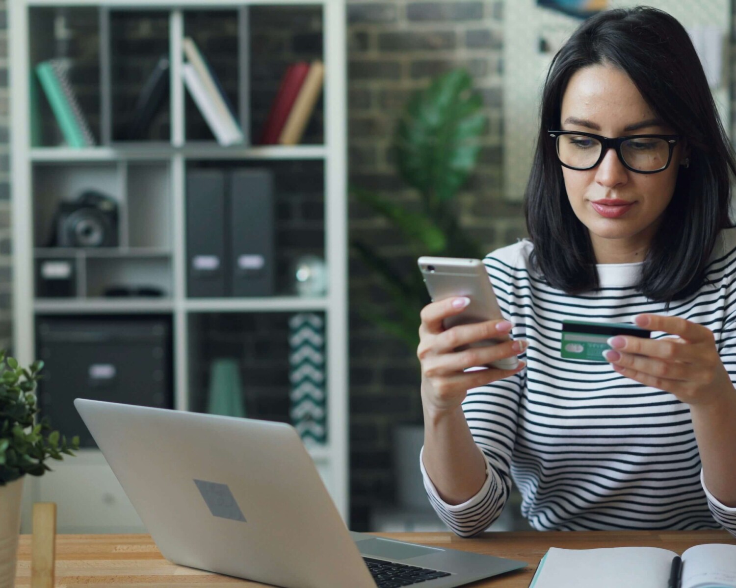 Lady looking at phone and credit card