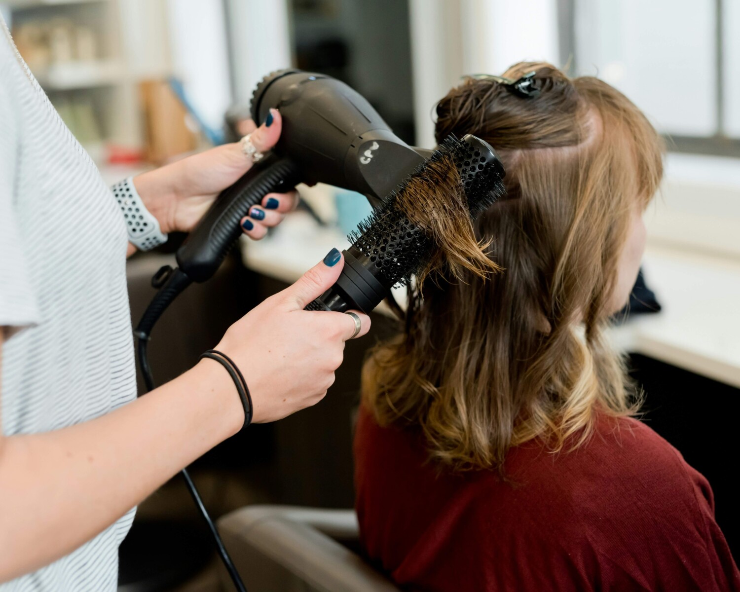 Hairstylist styling client's hair